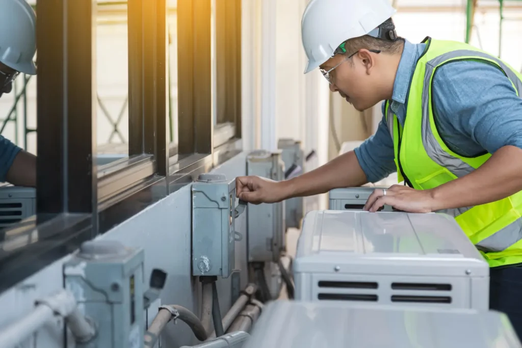 HVAC technician inspecting an outdoor air conditioning unit for maintenance.