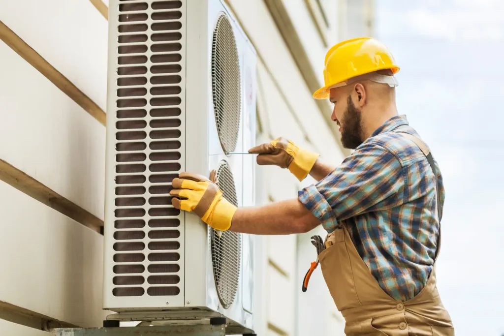Technician providing 24 hour AC service for an outdoor cooling unit.