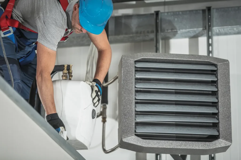 Technician performing maintenance on an air conditioning system.