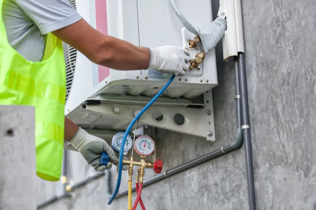 Technician checking refrigerant levels in an air conditioning unit.