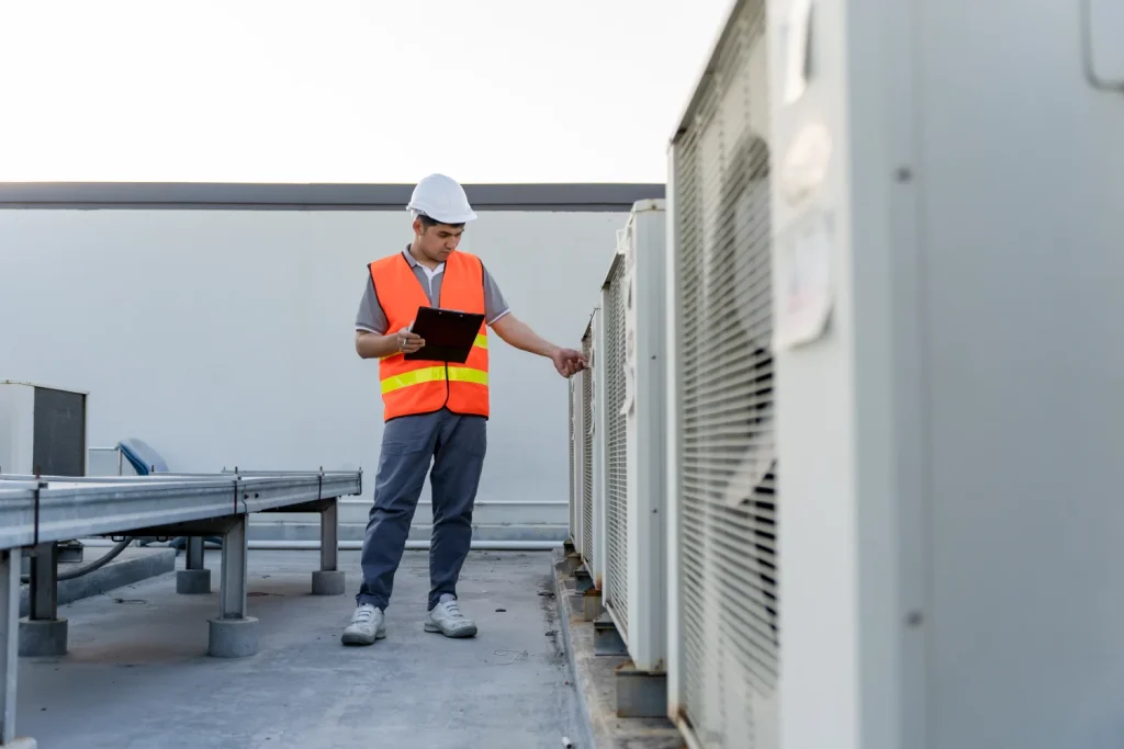 Technician inspecting rooftop AC units during a 24 hour AC service.