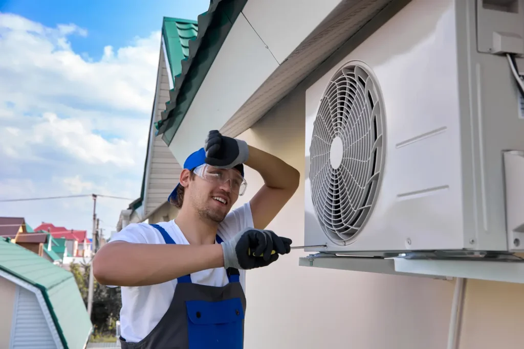 Technician performing maintenance on an outdoor air conditioning unit.